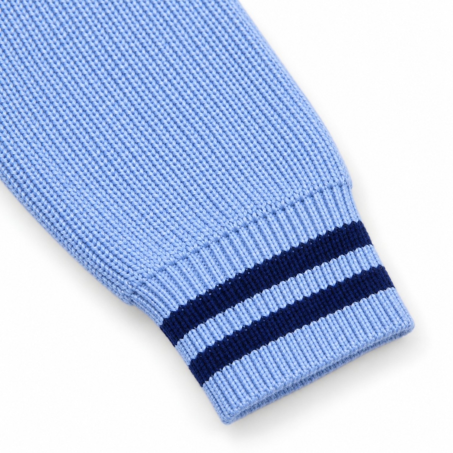 Close-up of the Colorblock Sporty Sweater sweater’s powder-blue knitted sleeve and ribbed cuff with navy stripes.