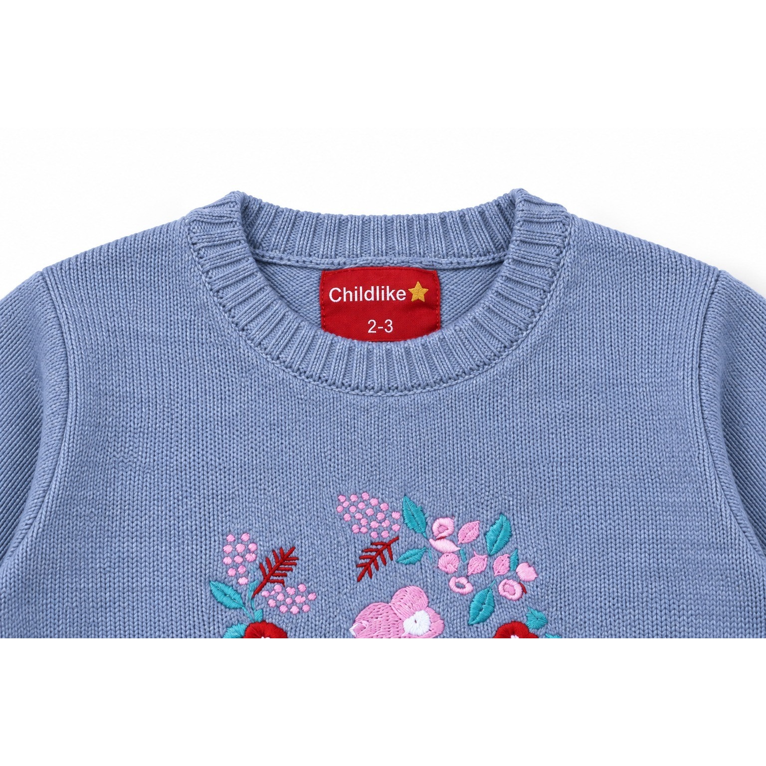 Close-up of the Bunny Garden Embroidered Sweater sweater’s ribbed crew neckline and red Childlike label.